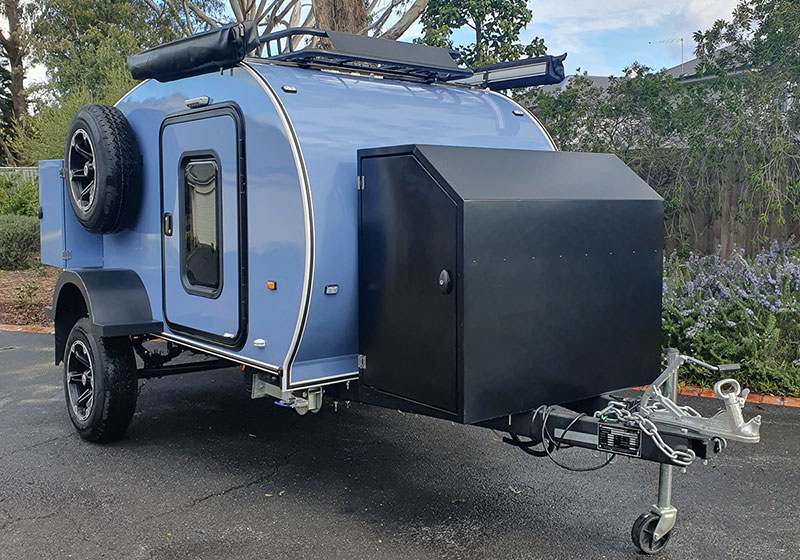 Three teardrop campers in blue, cream, and turquoise